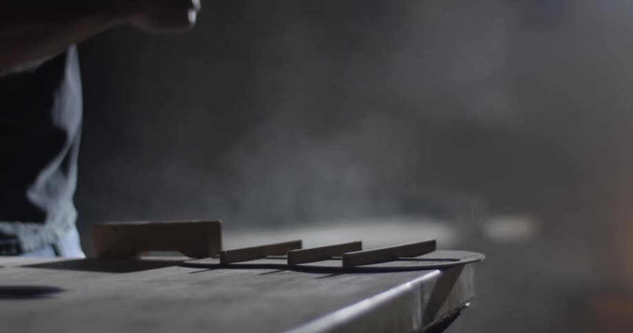 A person that is brushing dust off of a piece of wood