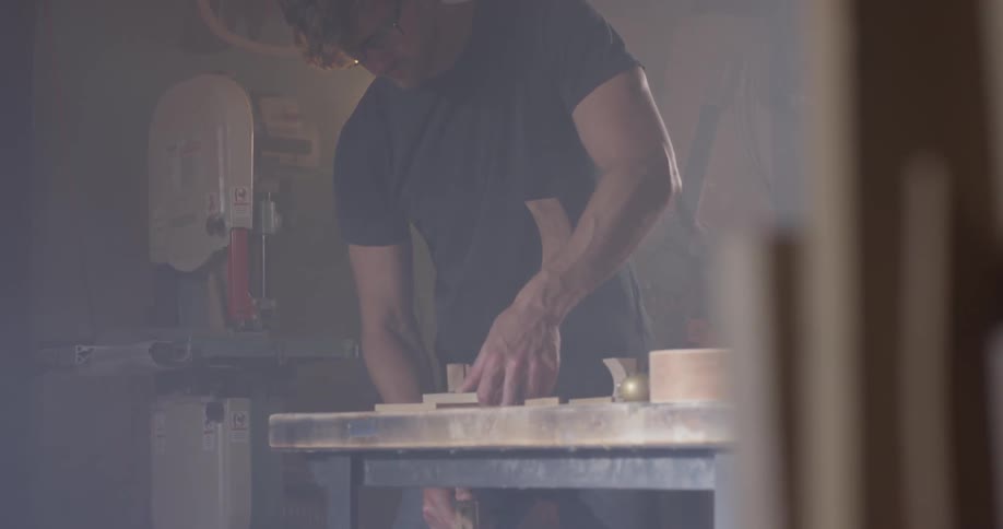 A man is working in his shop while using tools