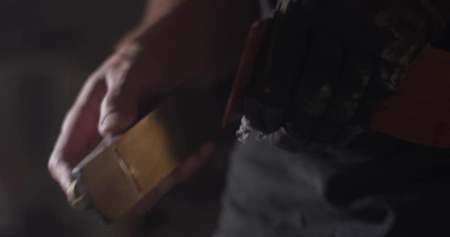 A man holds an object and polishes it with a tool