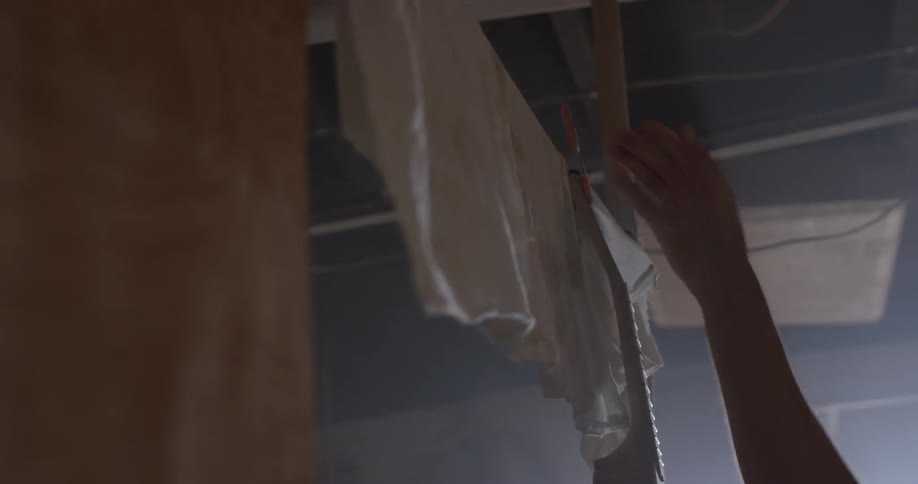 Someone hangs a tool from a line that has rags hanging from it