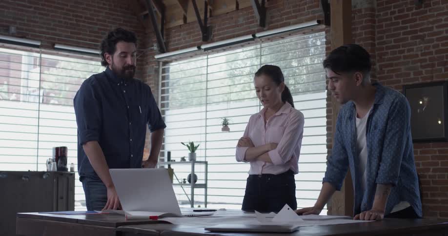 Three people are talking in a room indoors