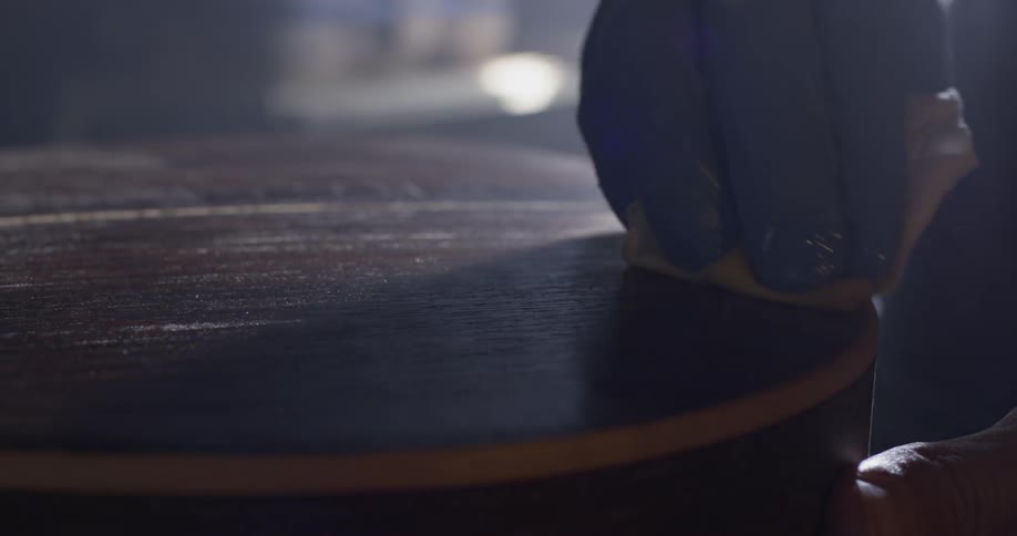 A person that is putting some stain on a guitar