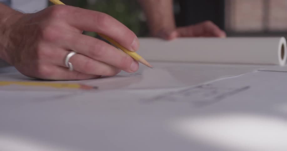 A person using a pencil to sketch on paper