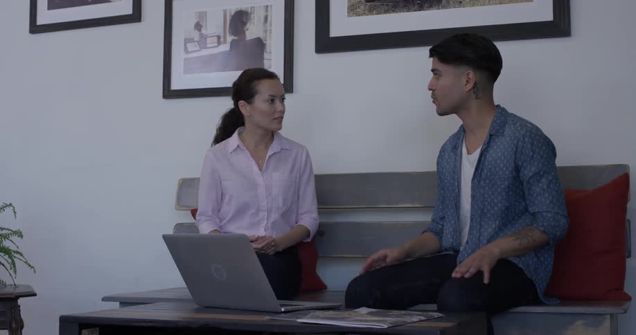 Two people talk to each other until they both look at a laptop