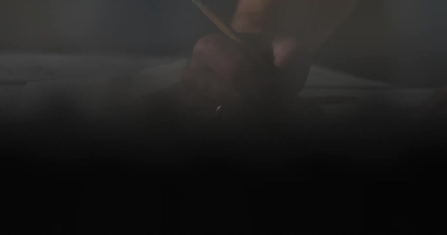 A person sketching on a piece of paper with a pencil