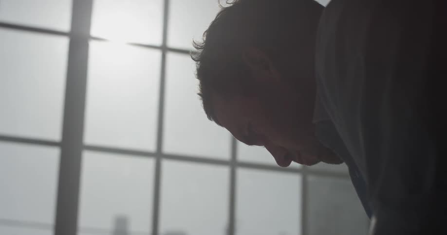 Man wearing a dress shirt looks down, while working on something