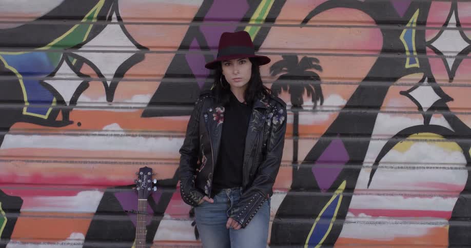 A woman standing in front of a mural on a garage door