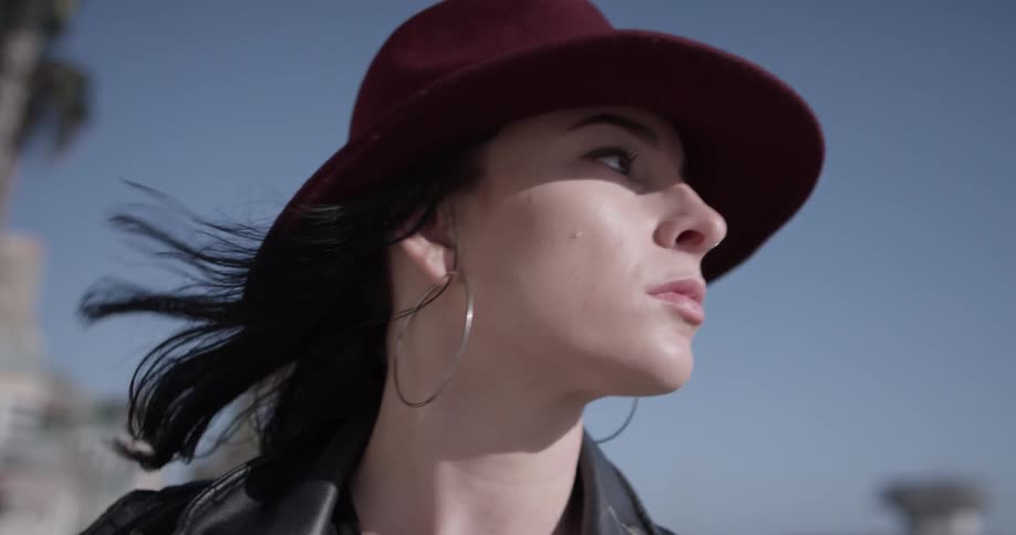 A woman with a hat walking on a windy day