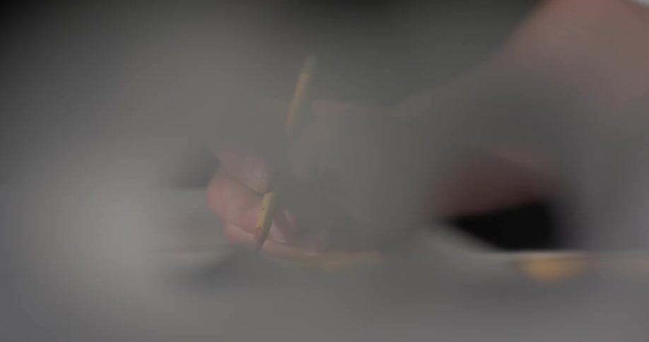 A person using a pencil to sketch in a book