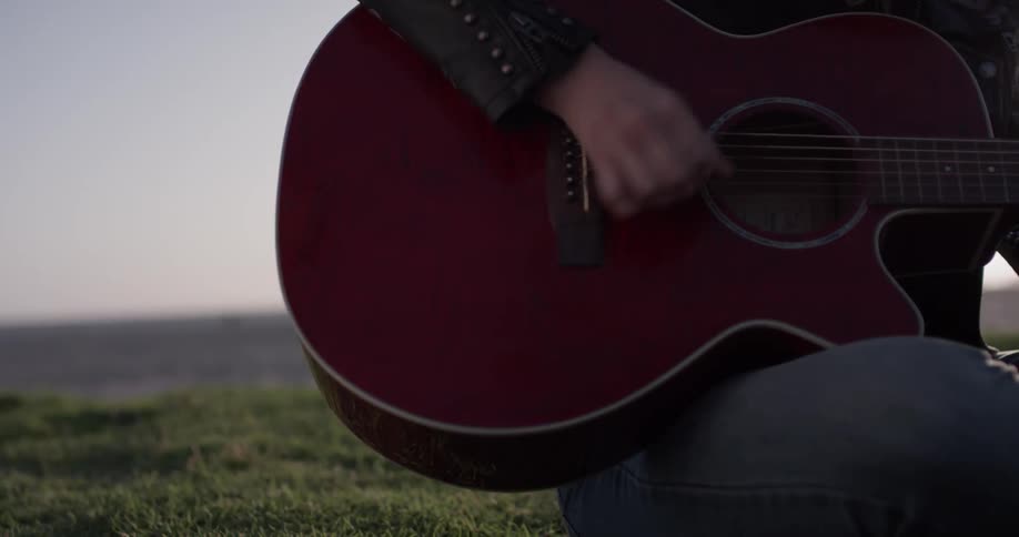 Closeup of woman playing acoustic guitar