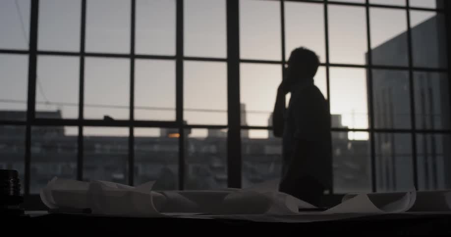A man on the phone is staring out the window while chatting
