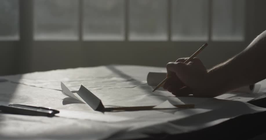 A person that is writing on a piece of paper