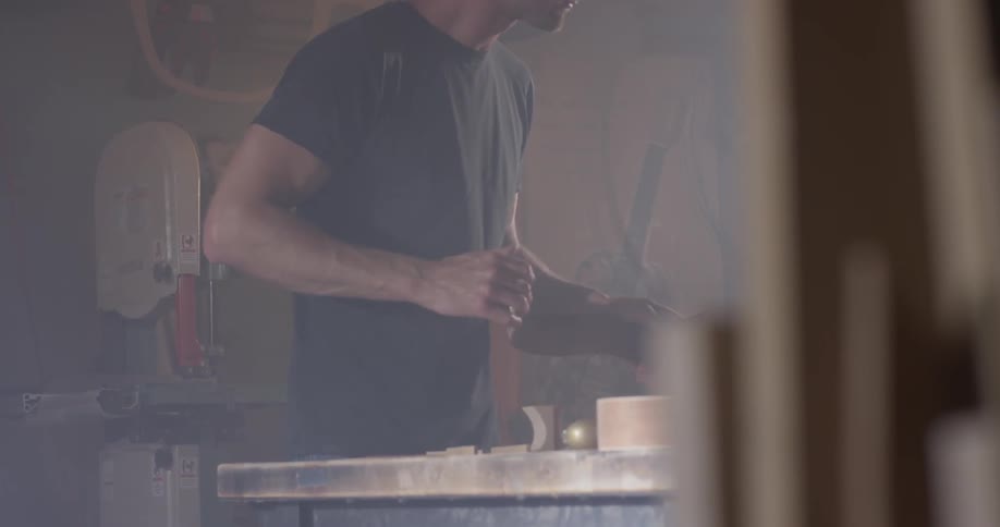 A man that is working on something in a wood shop