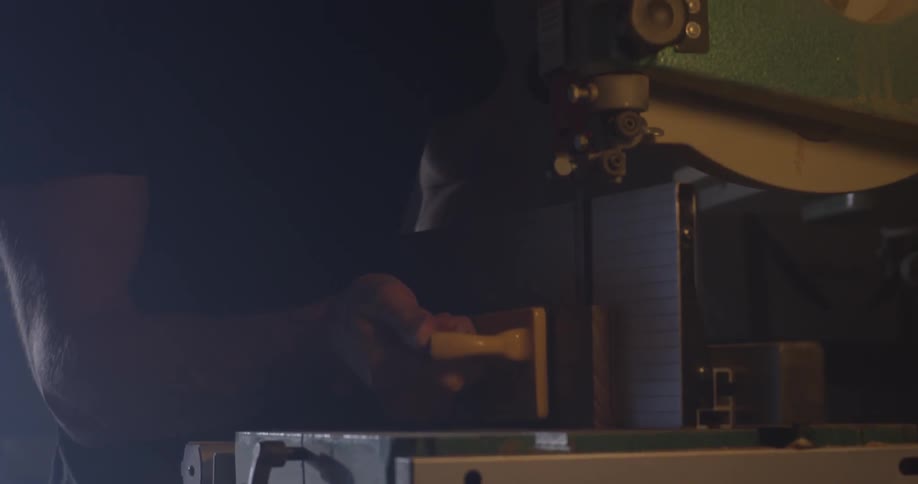 A person working on a machine in a wood shop