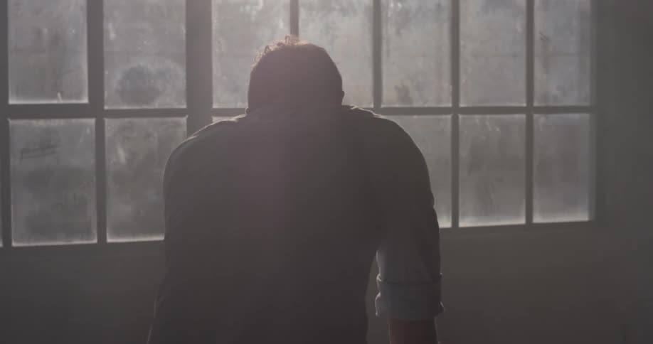 A man sketching in front of a window
