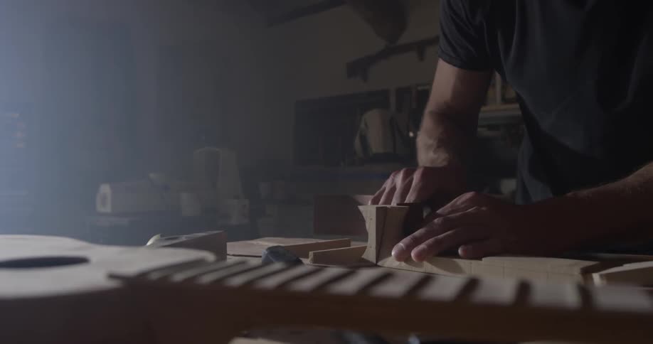 A man crafts an instrument in a workshop