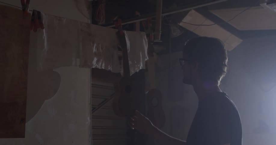 Carpenter Making Guitar In Workshop