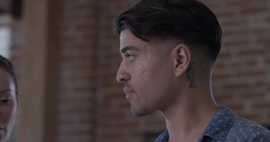 A man that is talking to someone else in an office