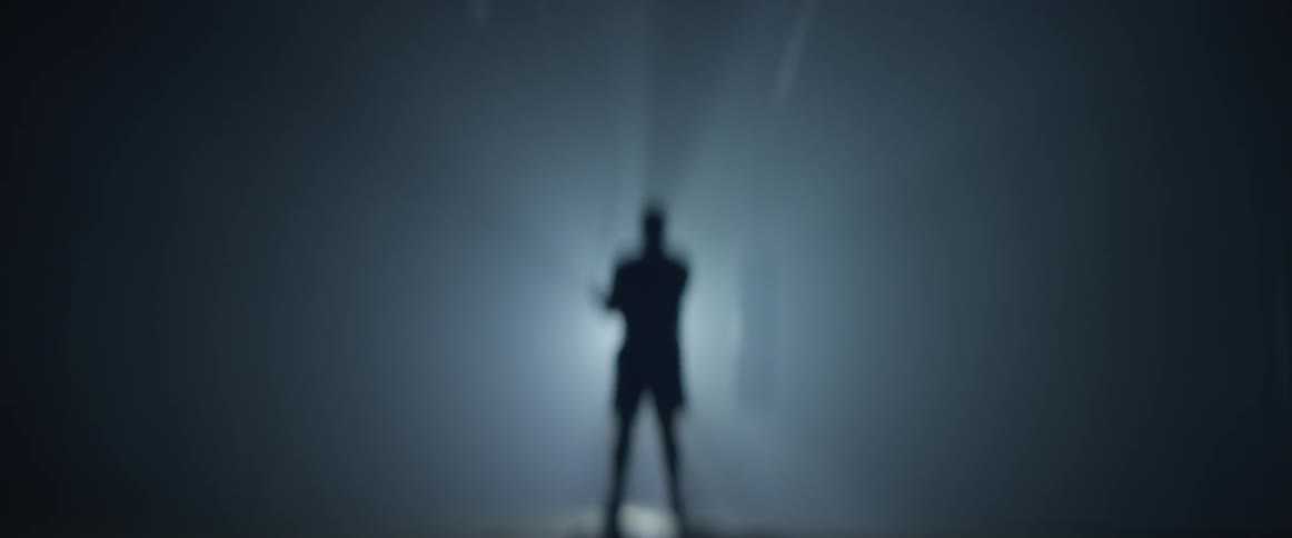 A man's silhouette moves in front of a bright light