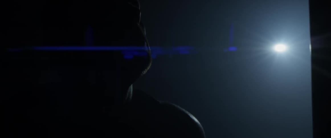 A man breathes deeply in a dark room