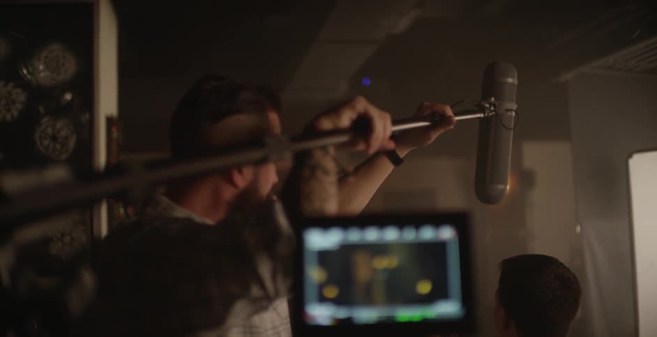 A man setting up a microphone indoors