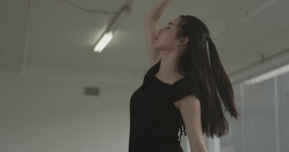 A woman stretches in a white room