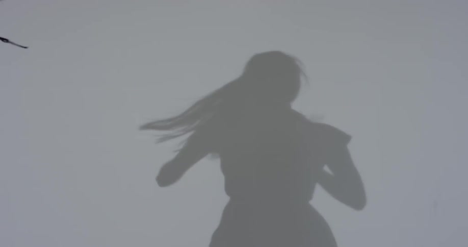 Shadow of a woman dancing on a white wall