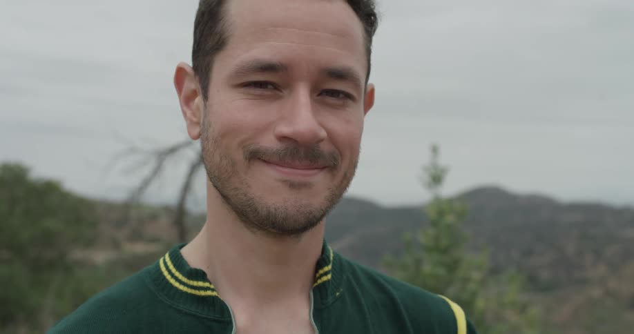 A portrait of a young man smiling outdoors