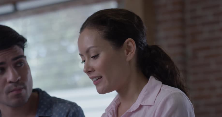 A woman showing a man something that is on a tablet