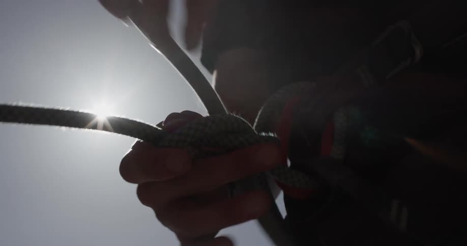 A person is making a rope knot around their waist