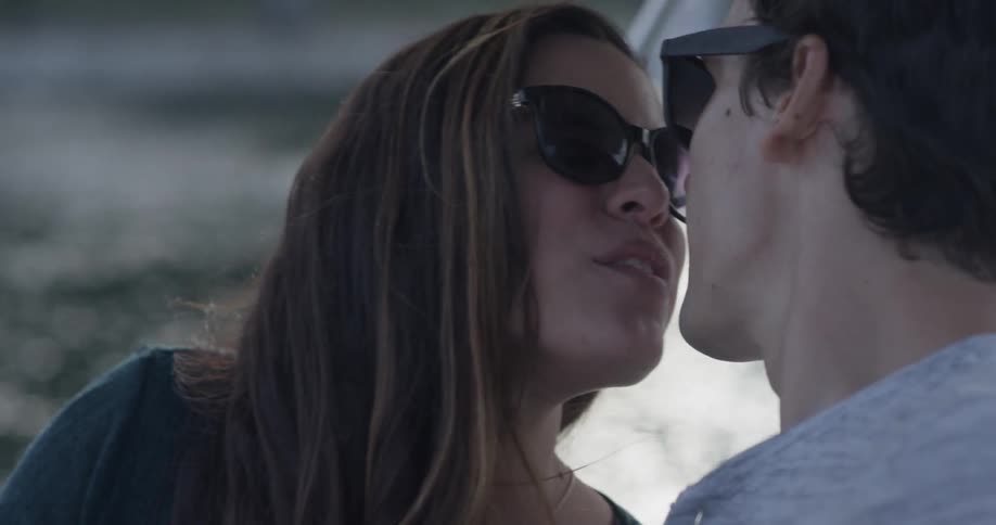 A man and a woman pose for a selfie than kiss each other