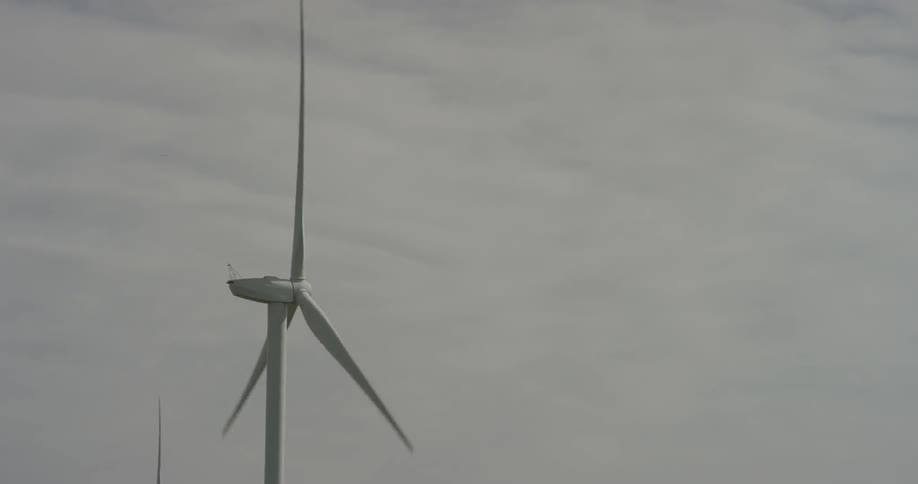 Windmills spinning in front of an overcast sky