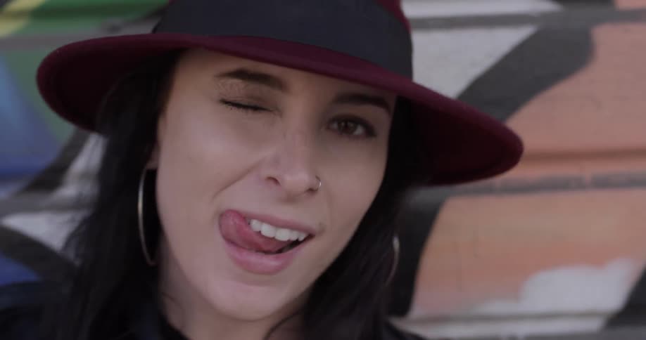 A woman sticks her tongue out toward her winking eye