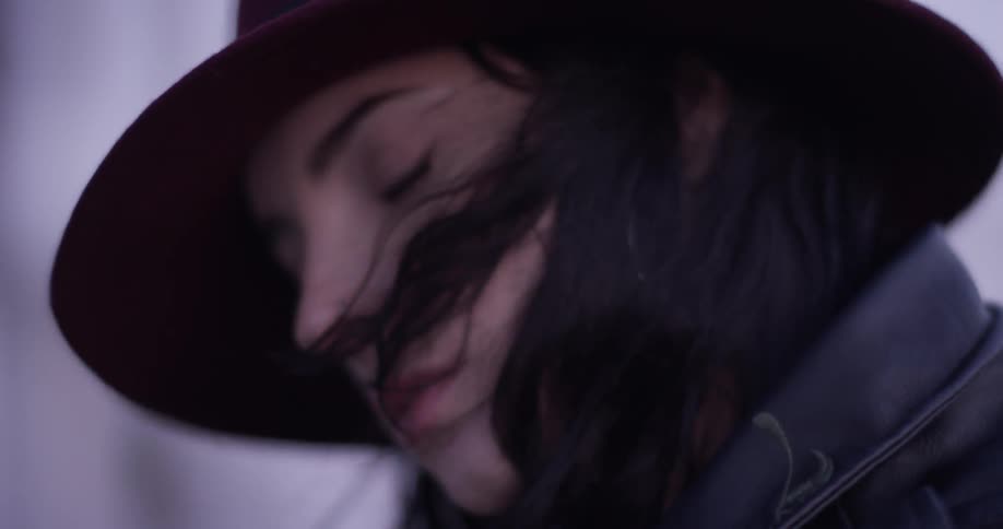A woman with a leather jacket out in a windy day