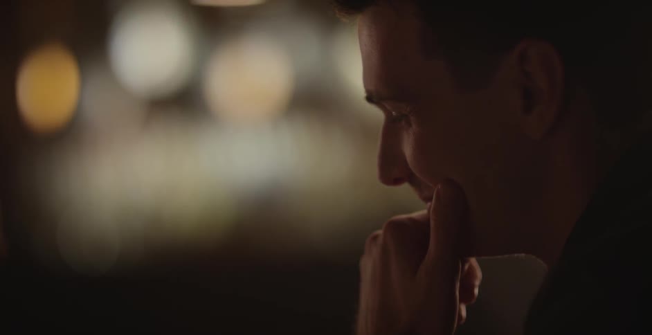 A man laughing and putting his hand on his chin