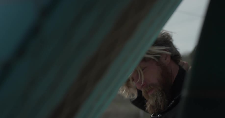 A man is fixing his wetsuit