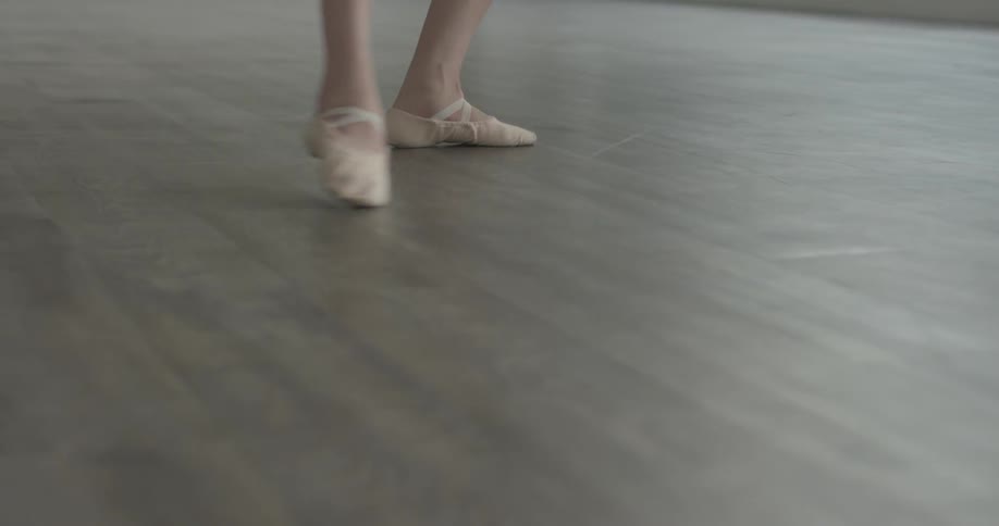 A female wearing ballerina shoes is dancing