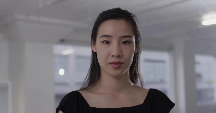 A woman in a black shirt stands in an empty room