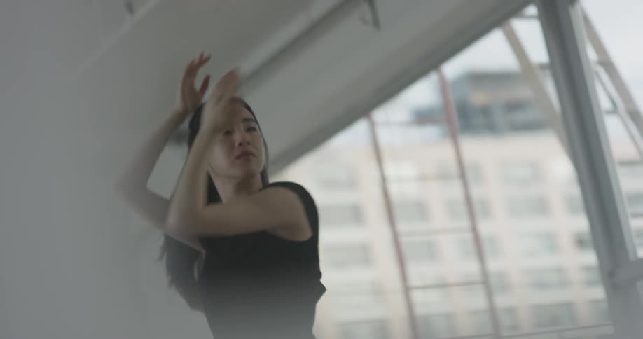 A woman that is dancing and moving her arms around