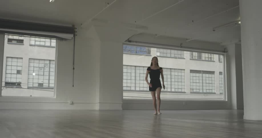A woman is doing ballet in a room