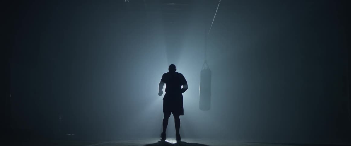 A man jumping rope in front of a boxing bag