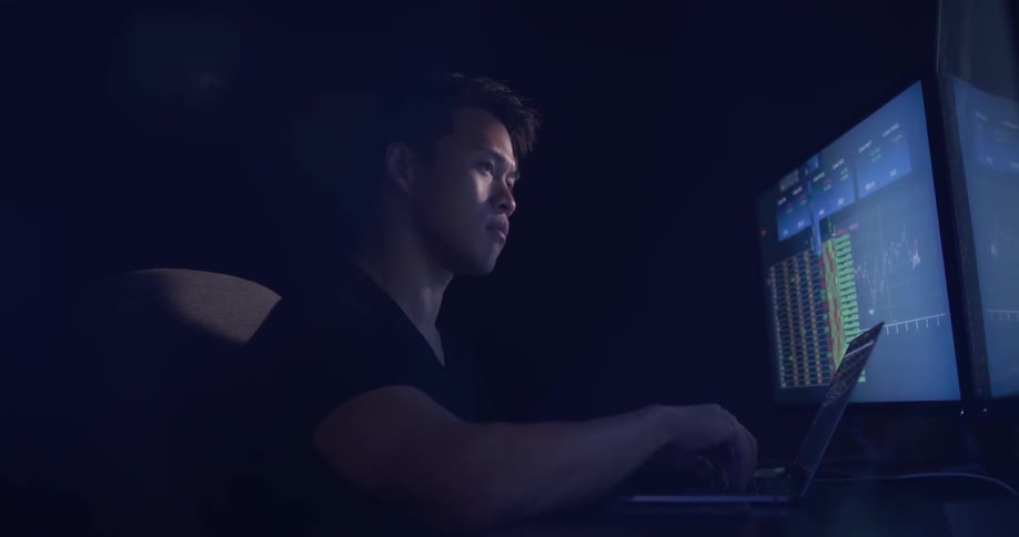 A man typing on a laptop computer at a desk