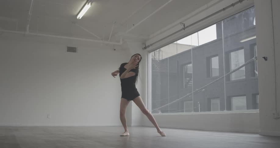 Woman dances by herself in empty room