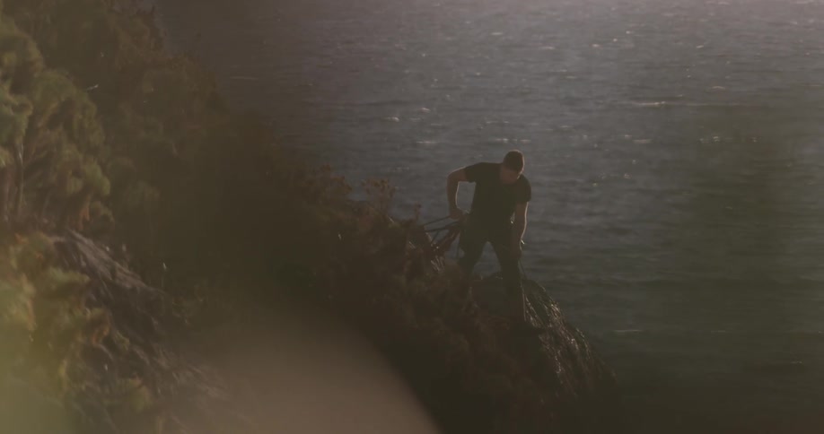 A man that is throwing some rope off of a cliff