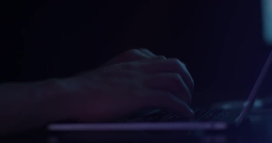 Someone types on a keyboard in the darkness