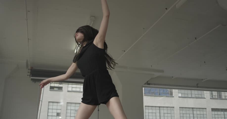 A woman runs and jumps through the air and continues a dance