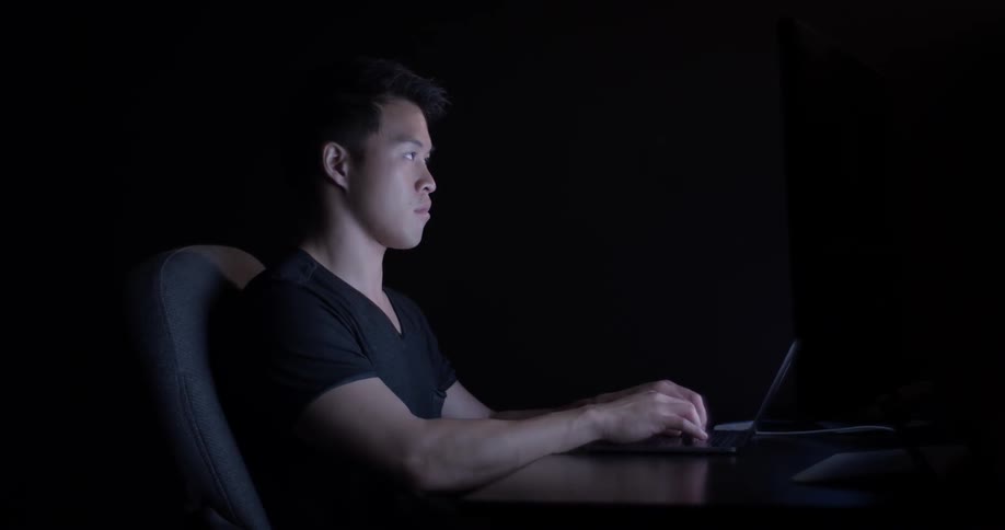 Man types on a keyboard at a desk