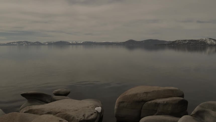 A body of water flows smoothly beside rocks