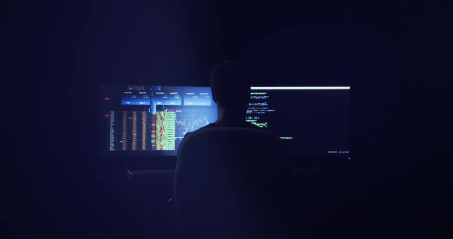 A person sitting in front of multiple computer monitors