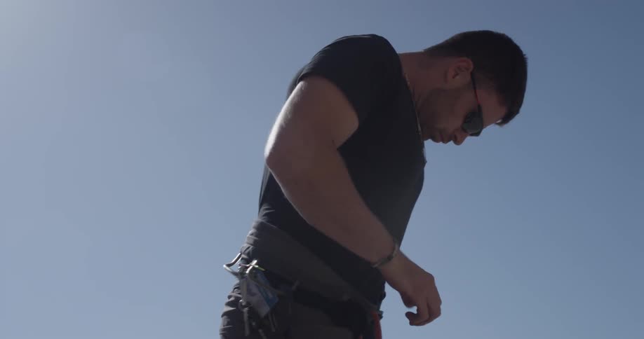 A man putting on a climbing harness